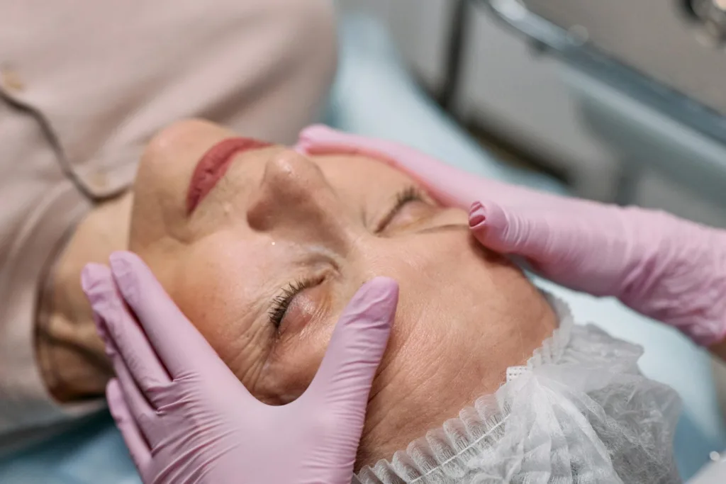 Senior woman looking relaxed gets a facial massage at a spa