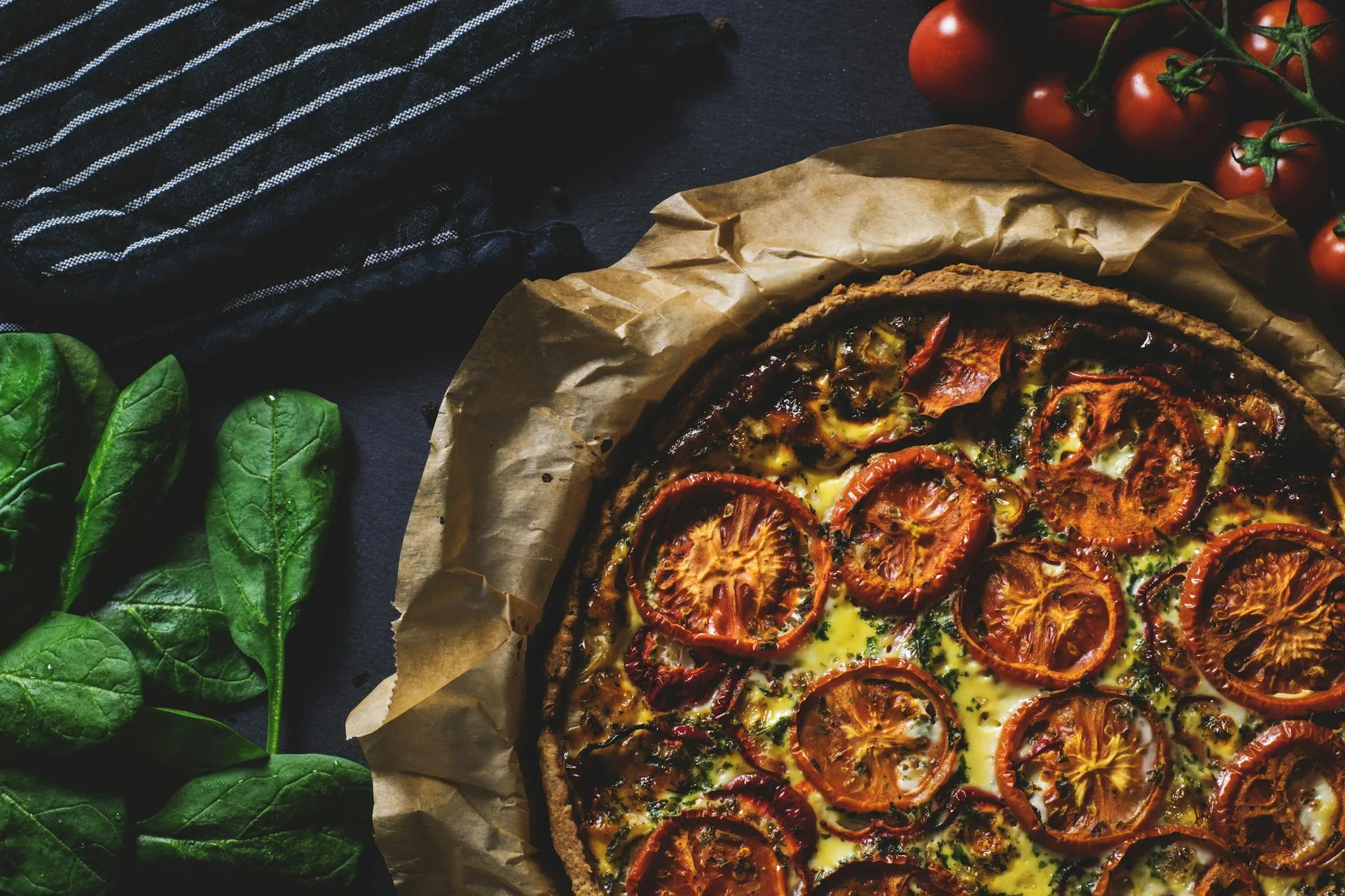 Freshly cooked pizza on a table with basil leaves