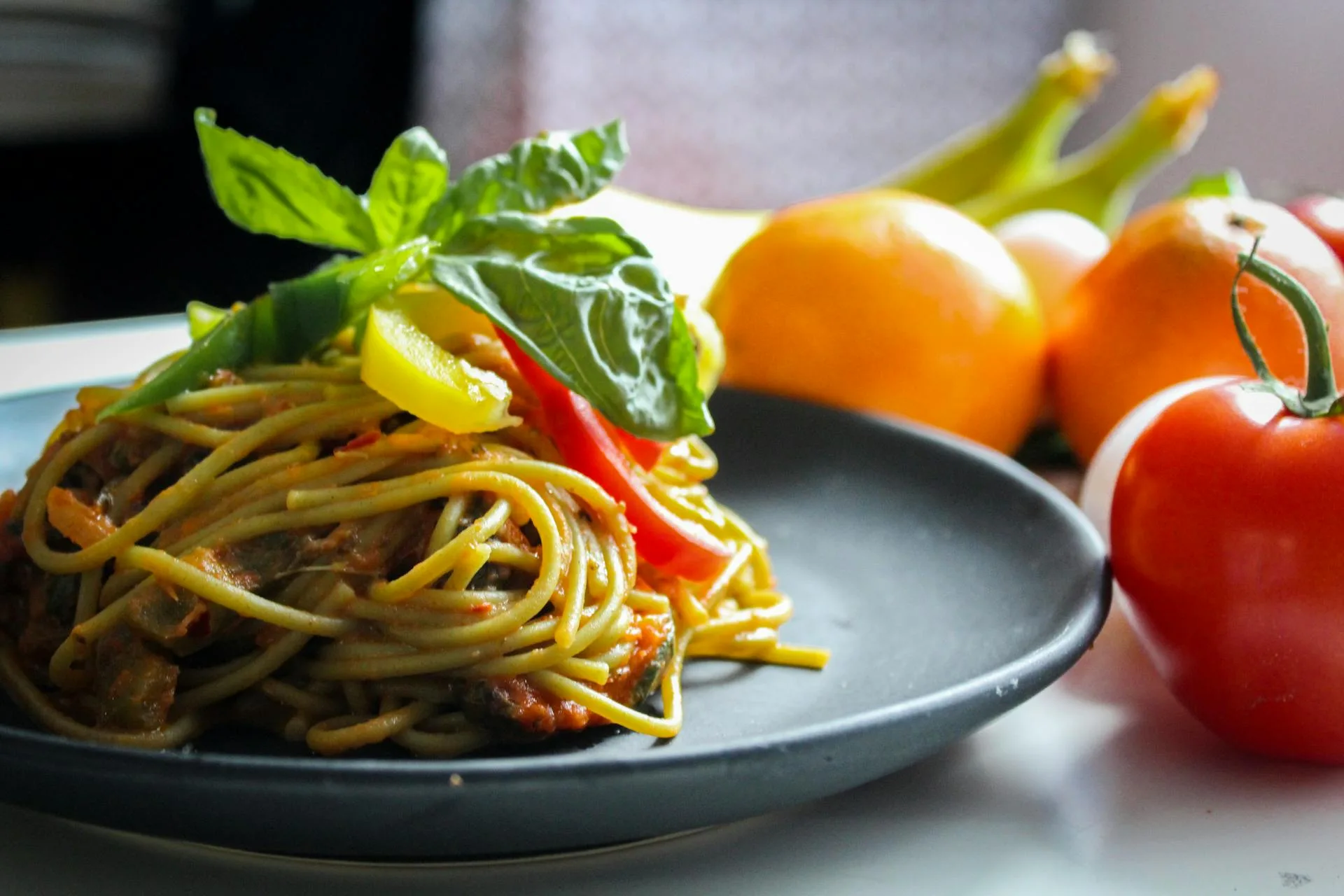 Healthy and delicious pasta dish with vegetables and fruit in the background