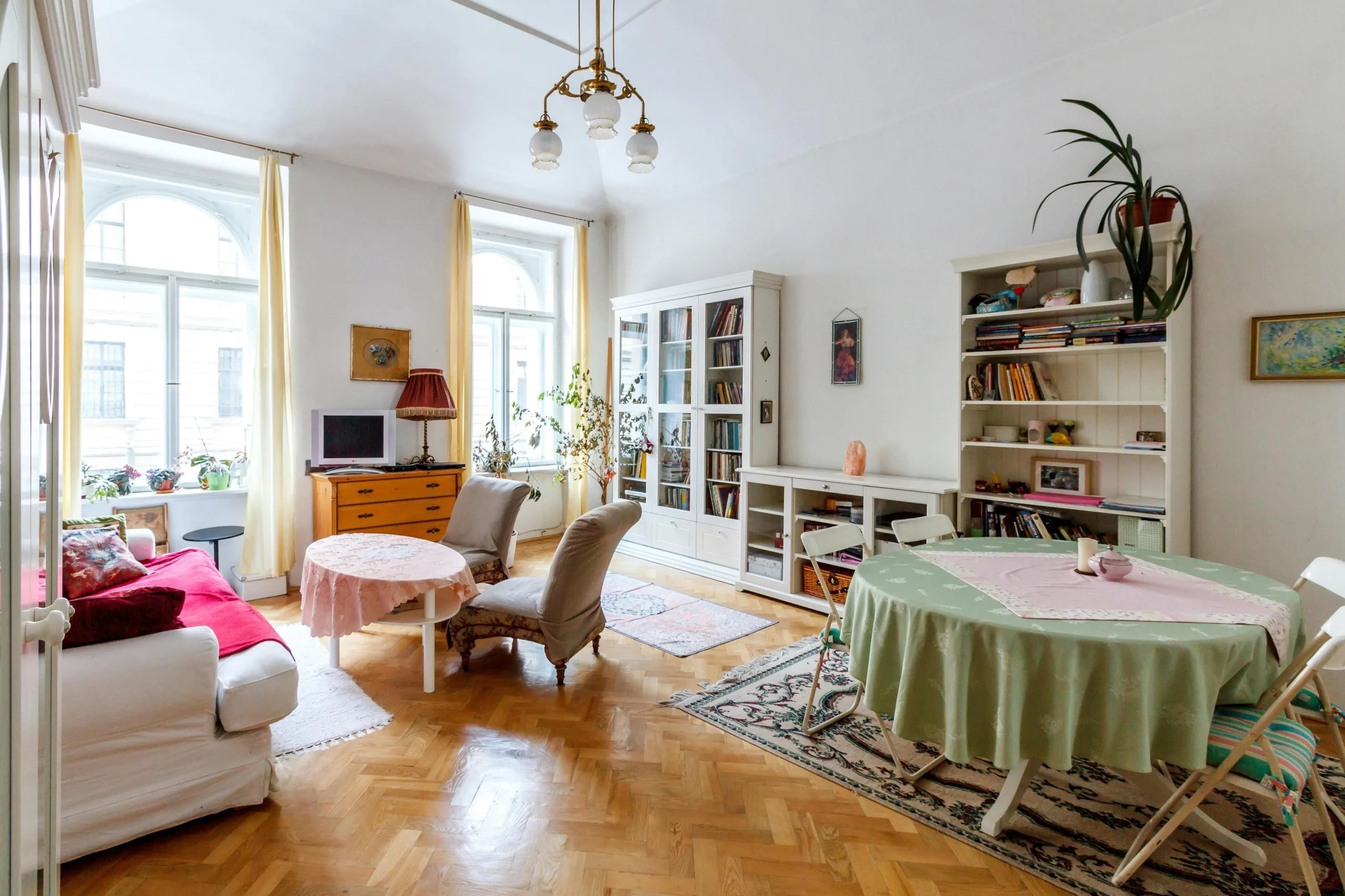 A sunlit sitting room with bookshelves and couches