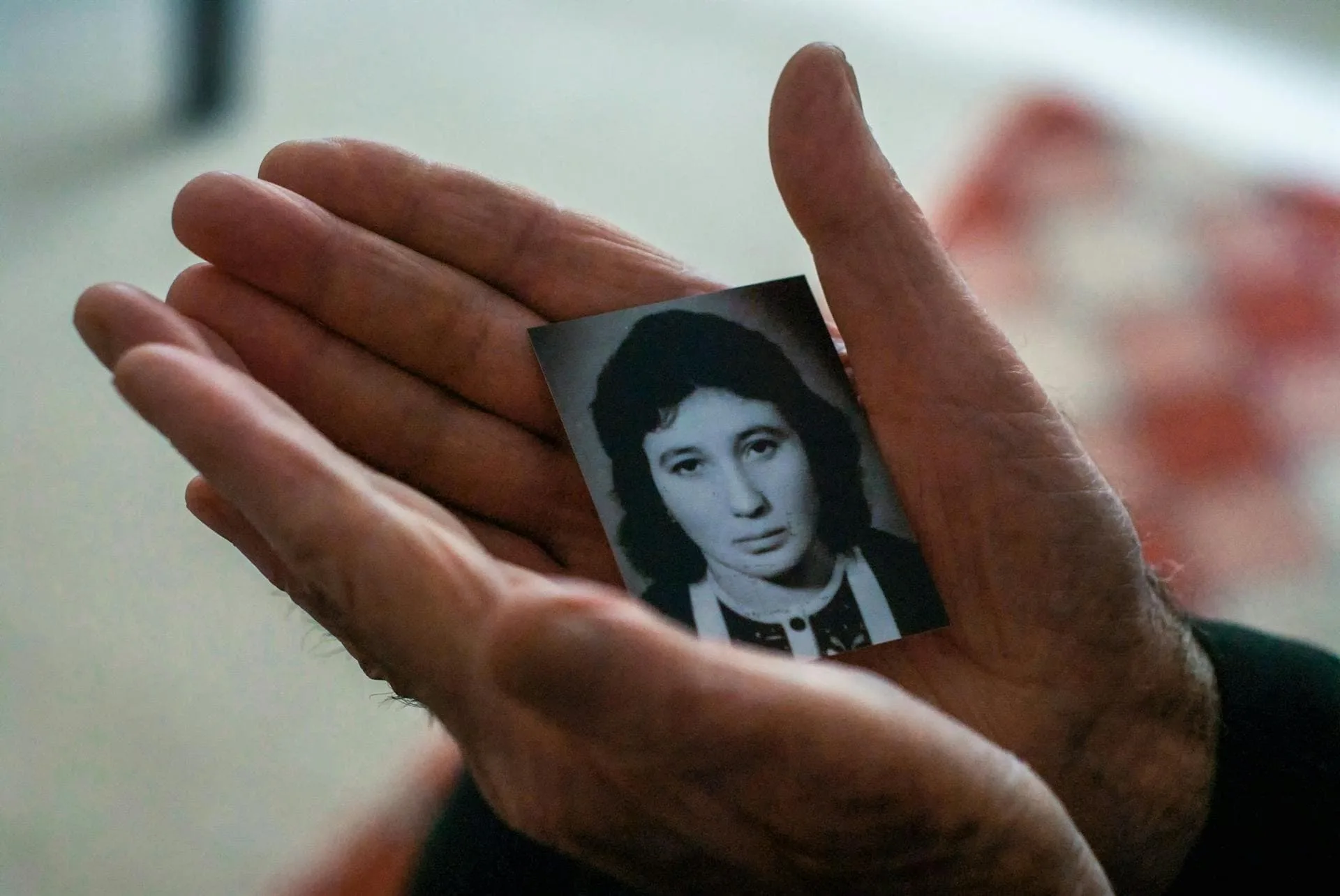 Close up of a senior's hands as they hold an old portrait photo