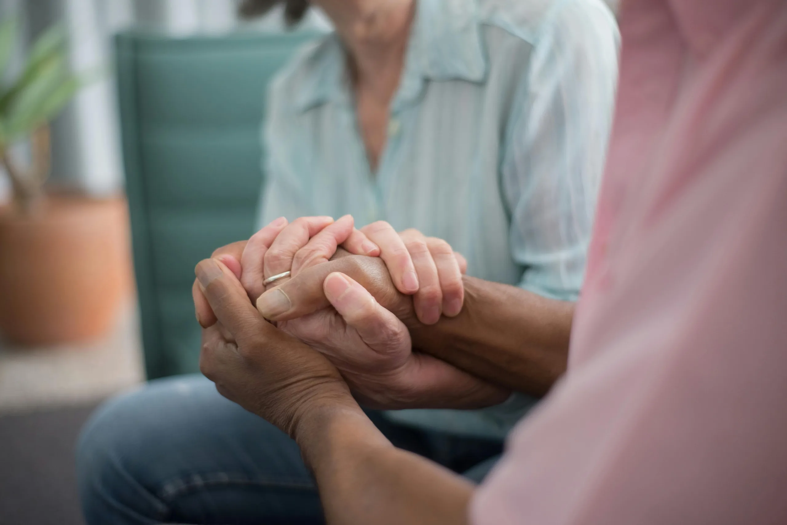 Close up of two seniors tenderly clasping hands