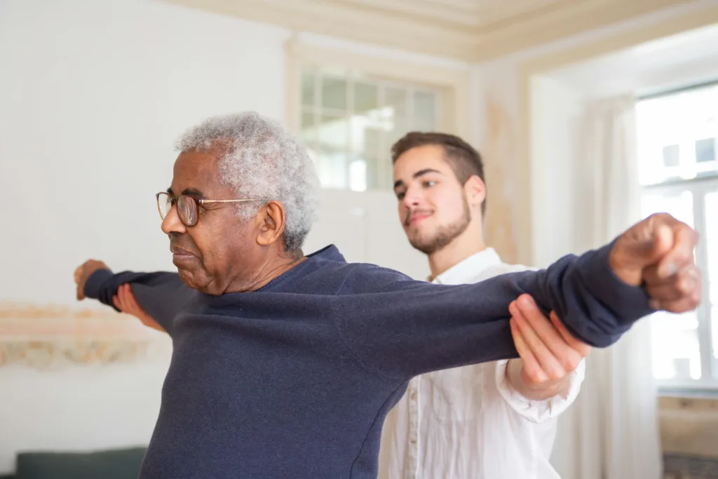 Smiling nurse leads a senior through stretching exercises