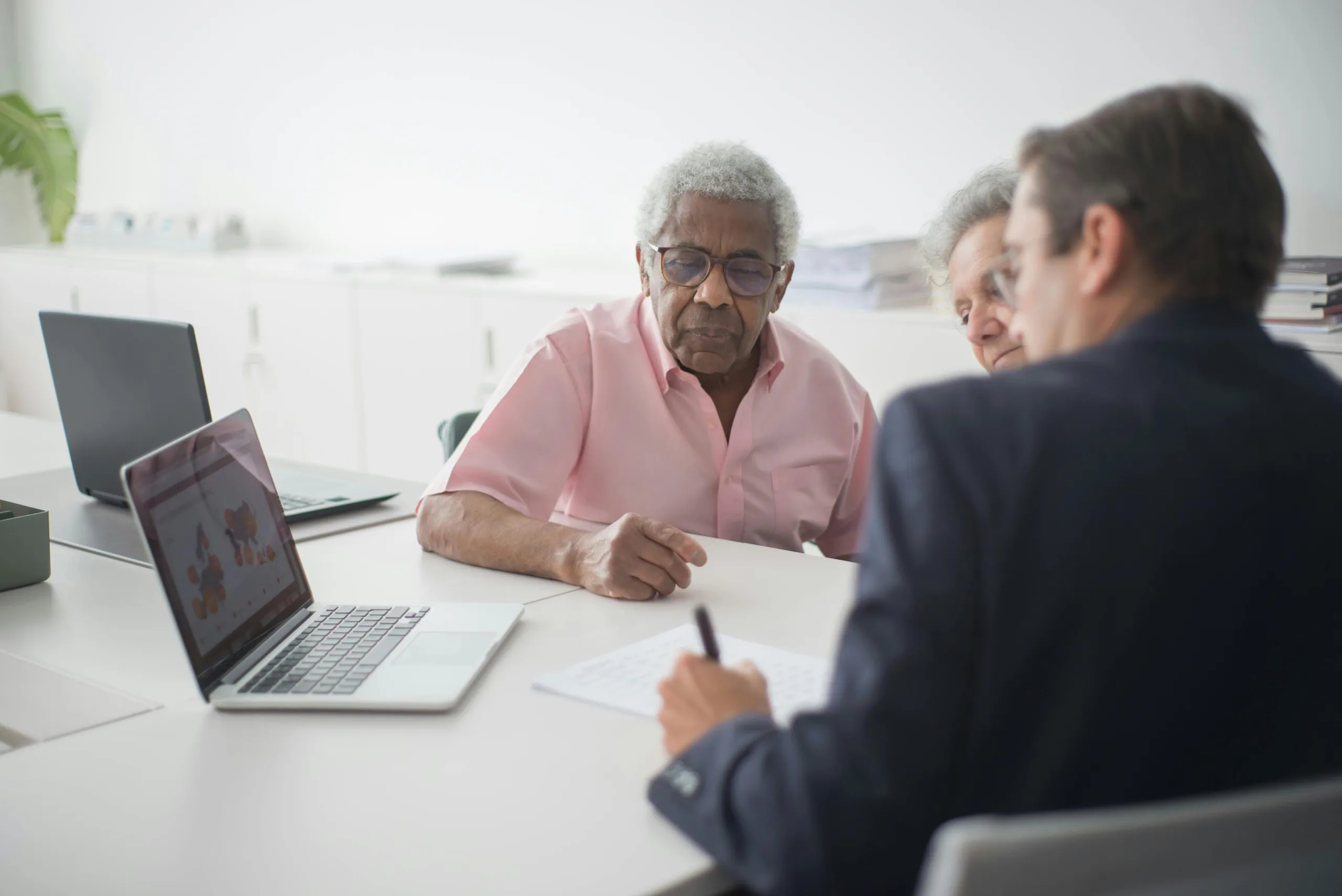 Elderly man and woman receiving help with paperwork