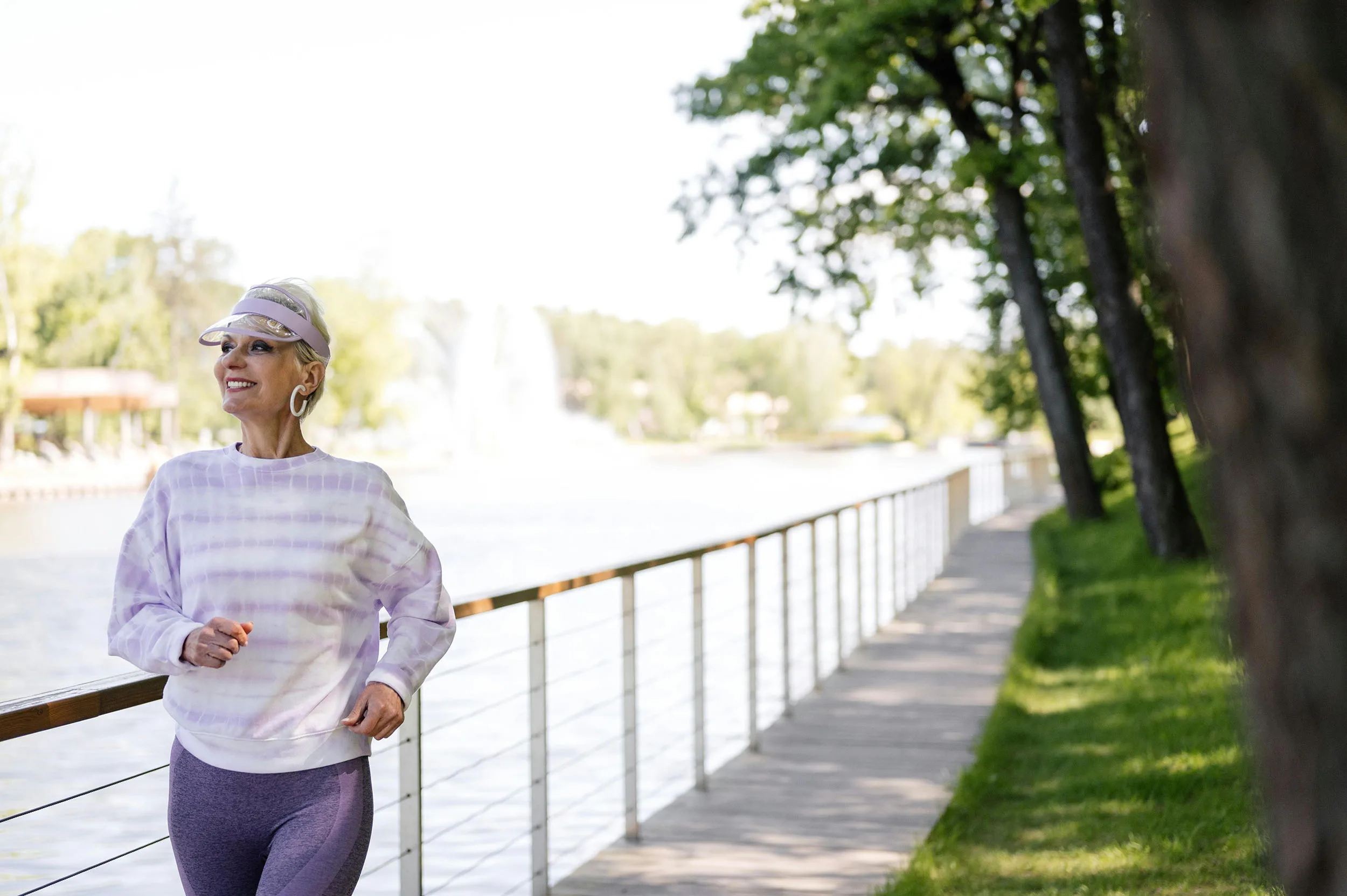 A woman grins as she walks on am outdoor trail